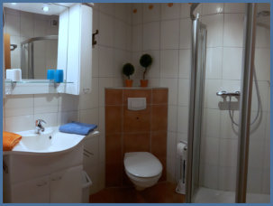Das Bad ist ausgestattet mit eine Runddusche, WC, Waschtischanlage, Föhn und Lockenstab.
